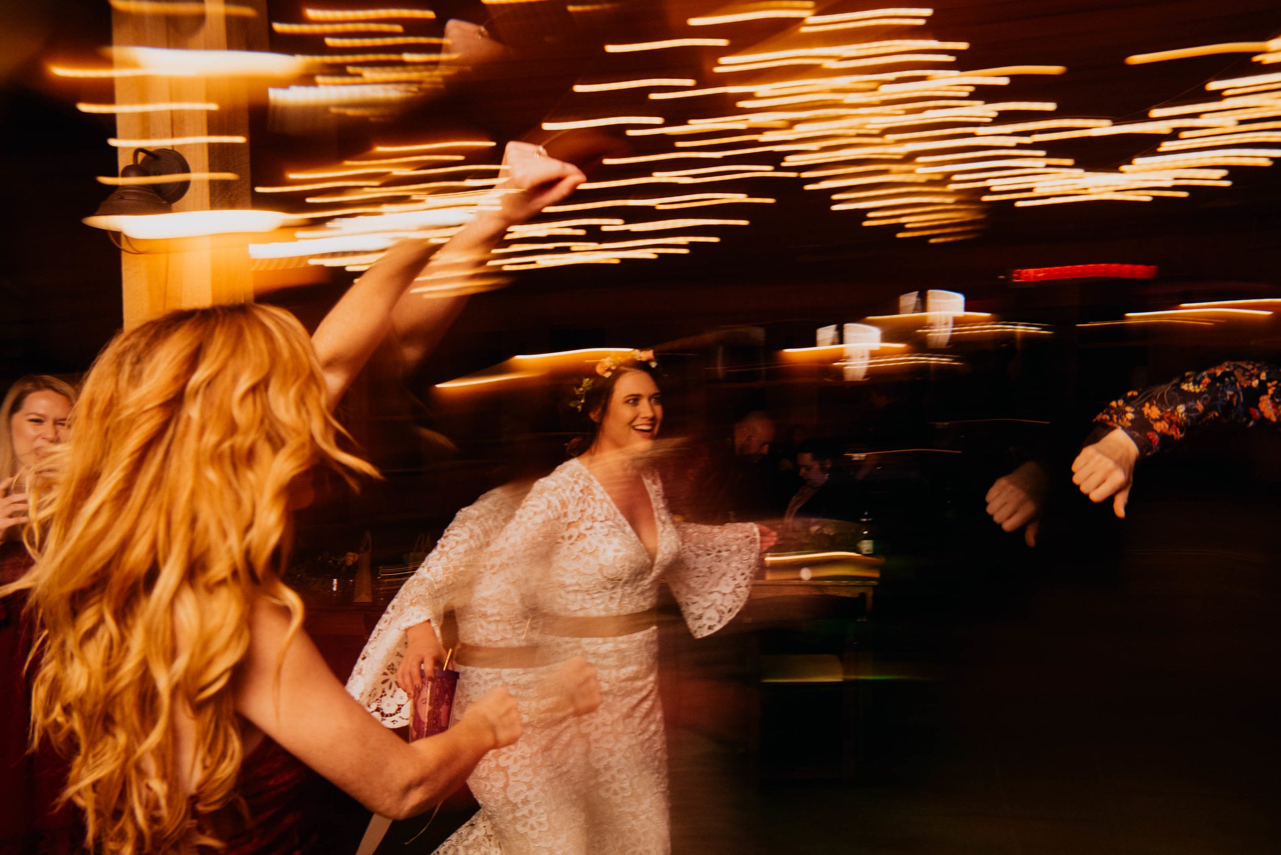 fun light trails while bride is dancing with her friends