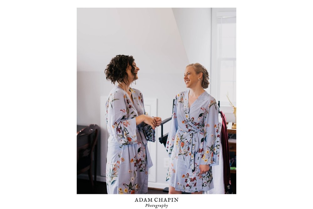 two of the bridesmaids laughing as they get ready for the wedding day