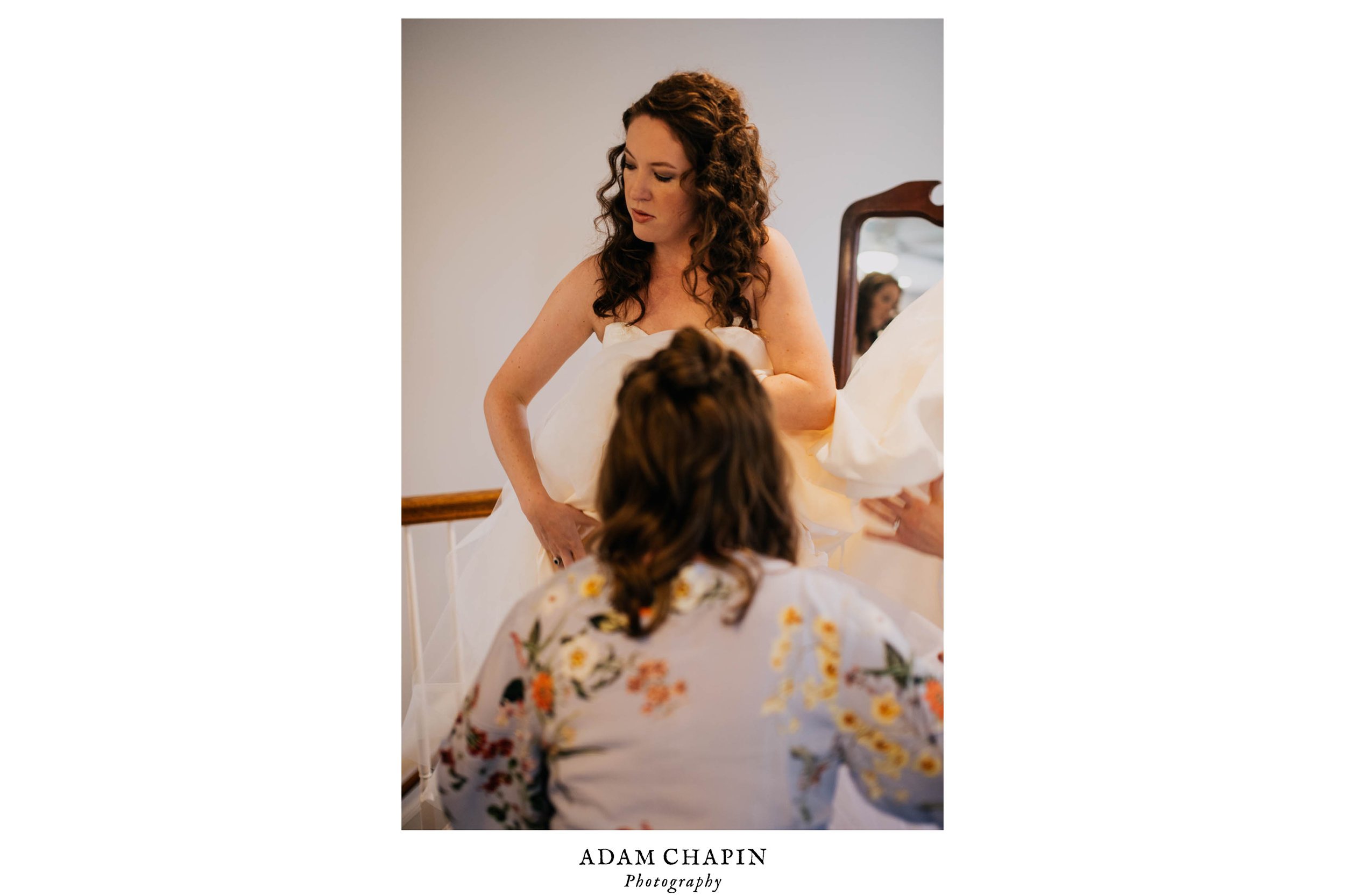 bride being helped with her wedding dress by one of her bridesmaids