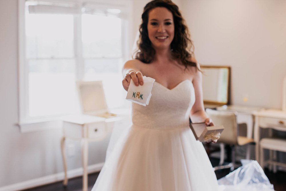 bride showing off her wedding gift from her bridesmaids