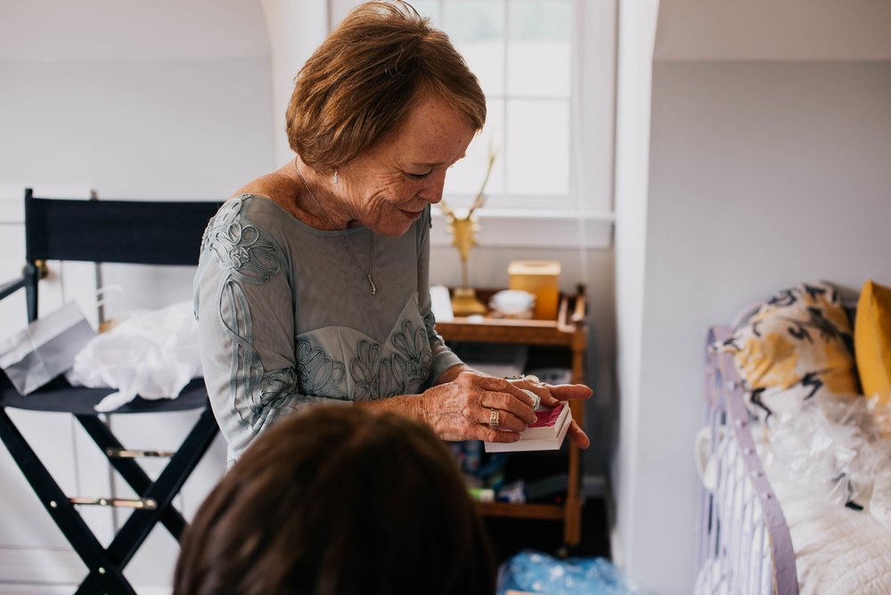 mother of the groom opening a gift to her from the bride