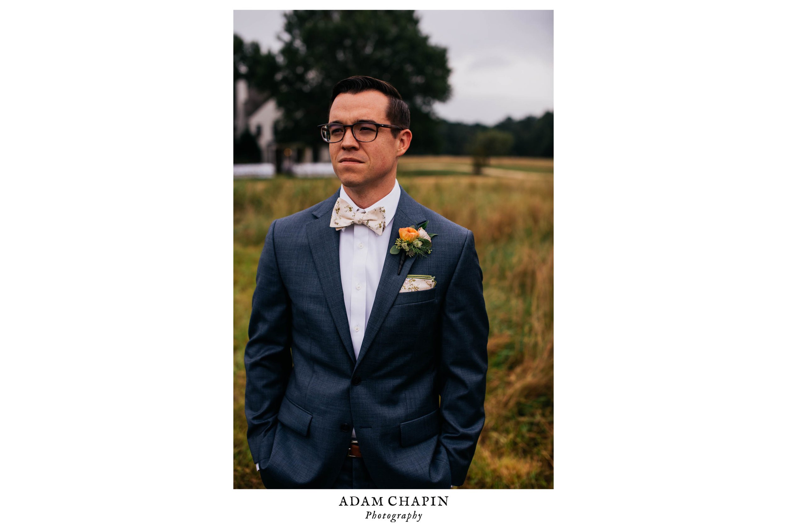 portrait of groom standing in a field before a first look with his bride before their wedding