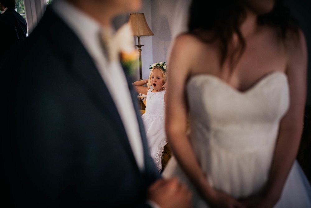 flower girl yawning in the background before the wedding ceremony