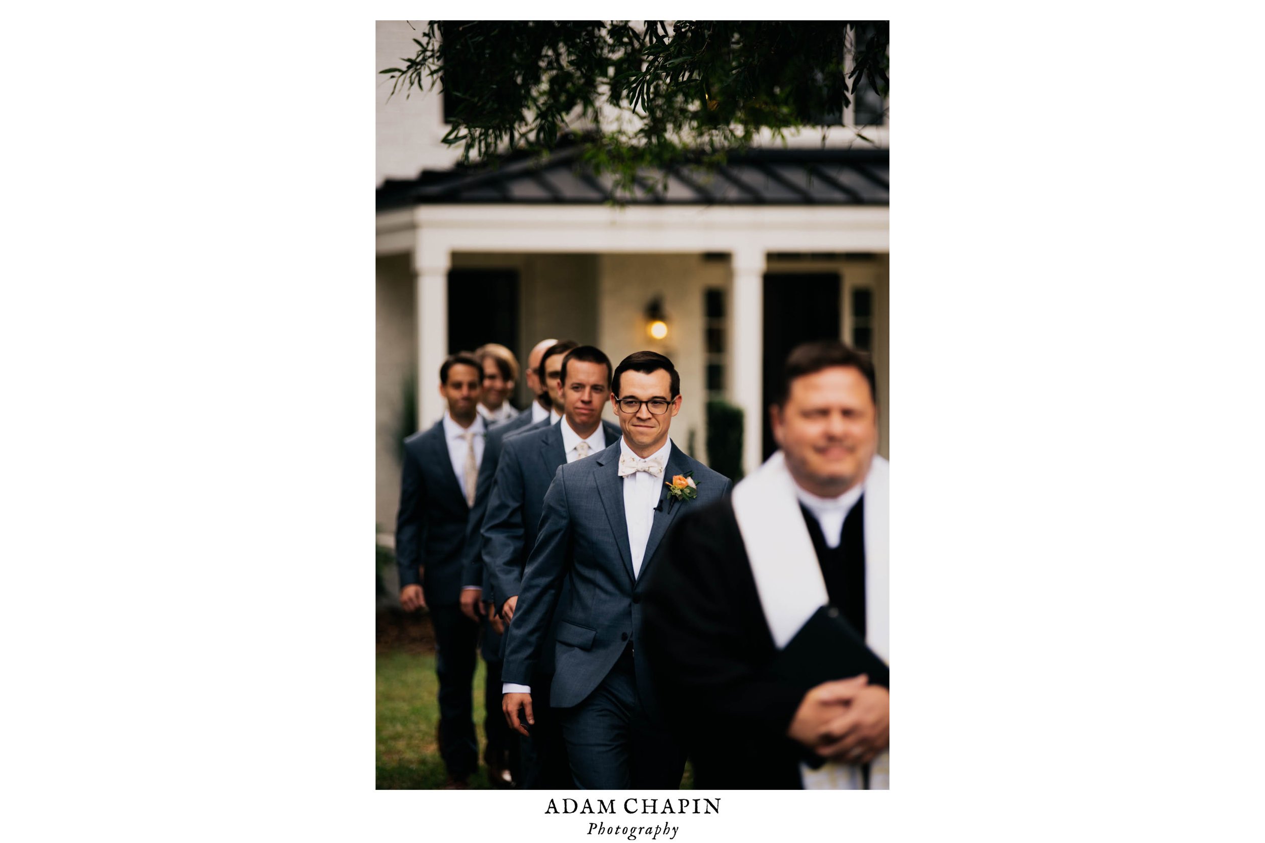 the groom, officiant and groomsmen walk down the aisle at the beginning of the ceremony