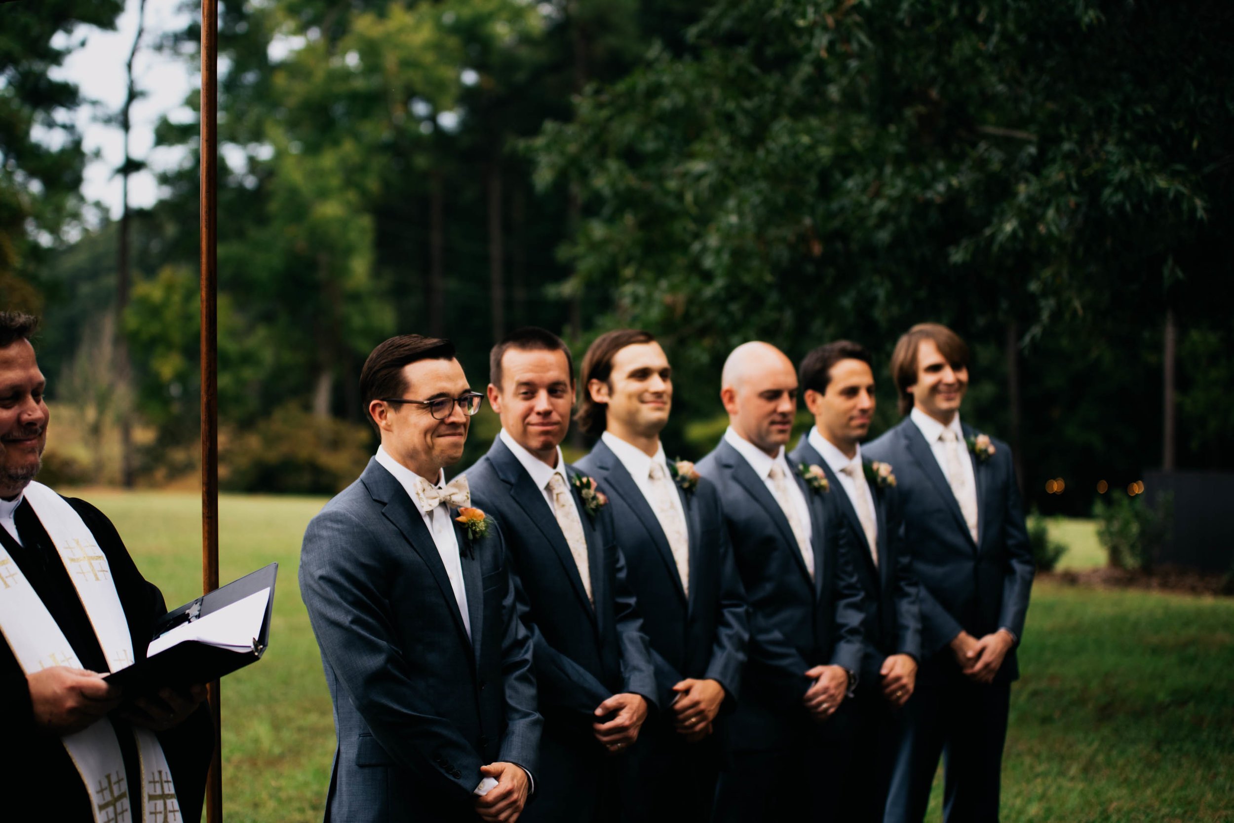 groom and his groomsmen watching the bride walk down the aisle