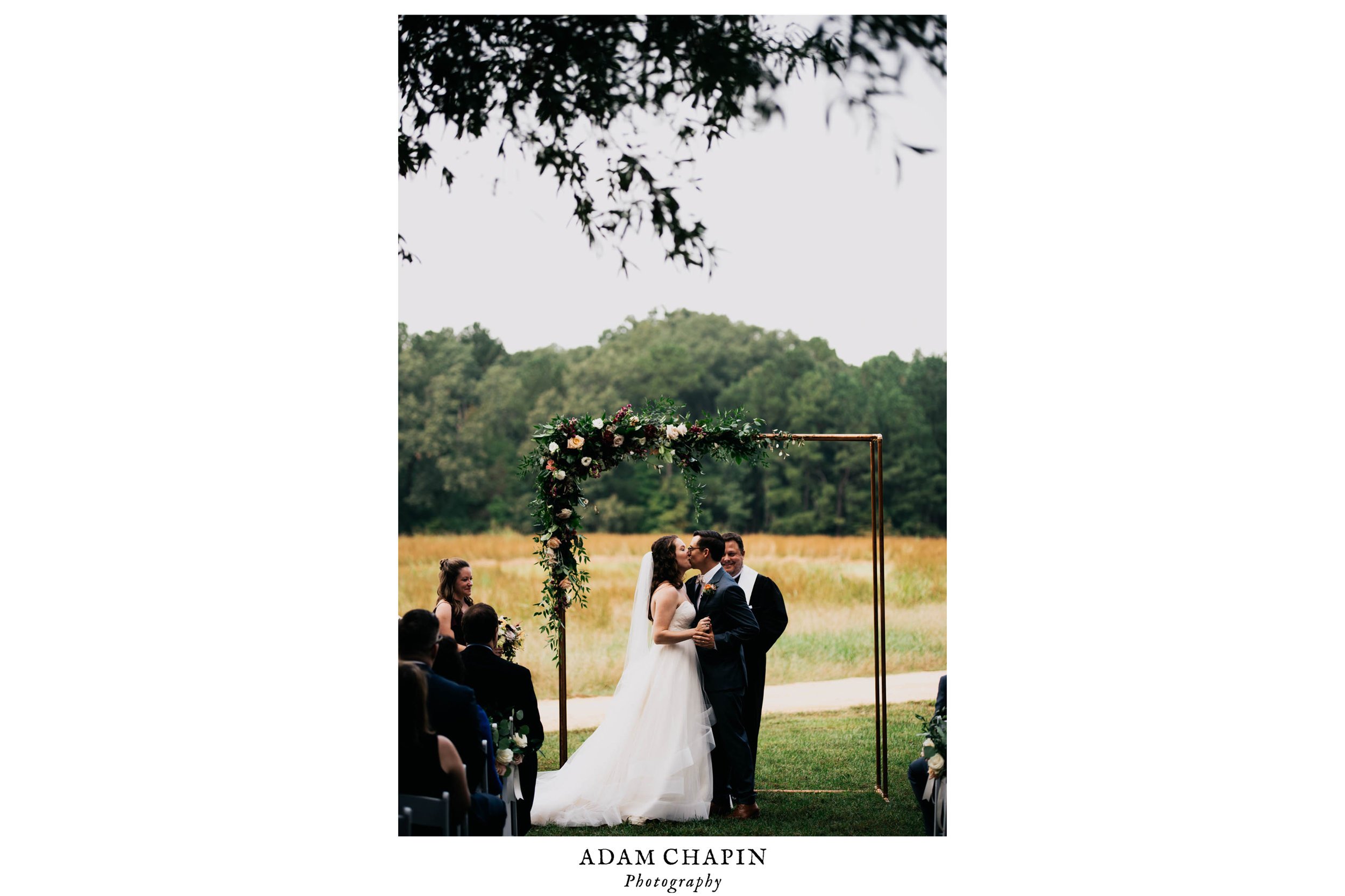 bride and grooms first kiss during their wedding ceremony