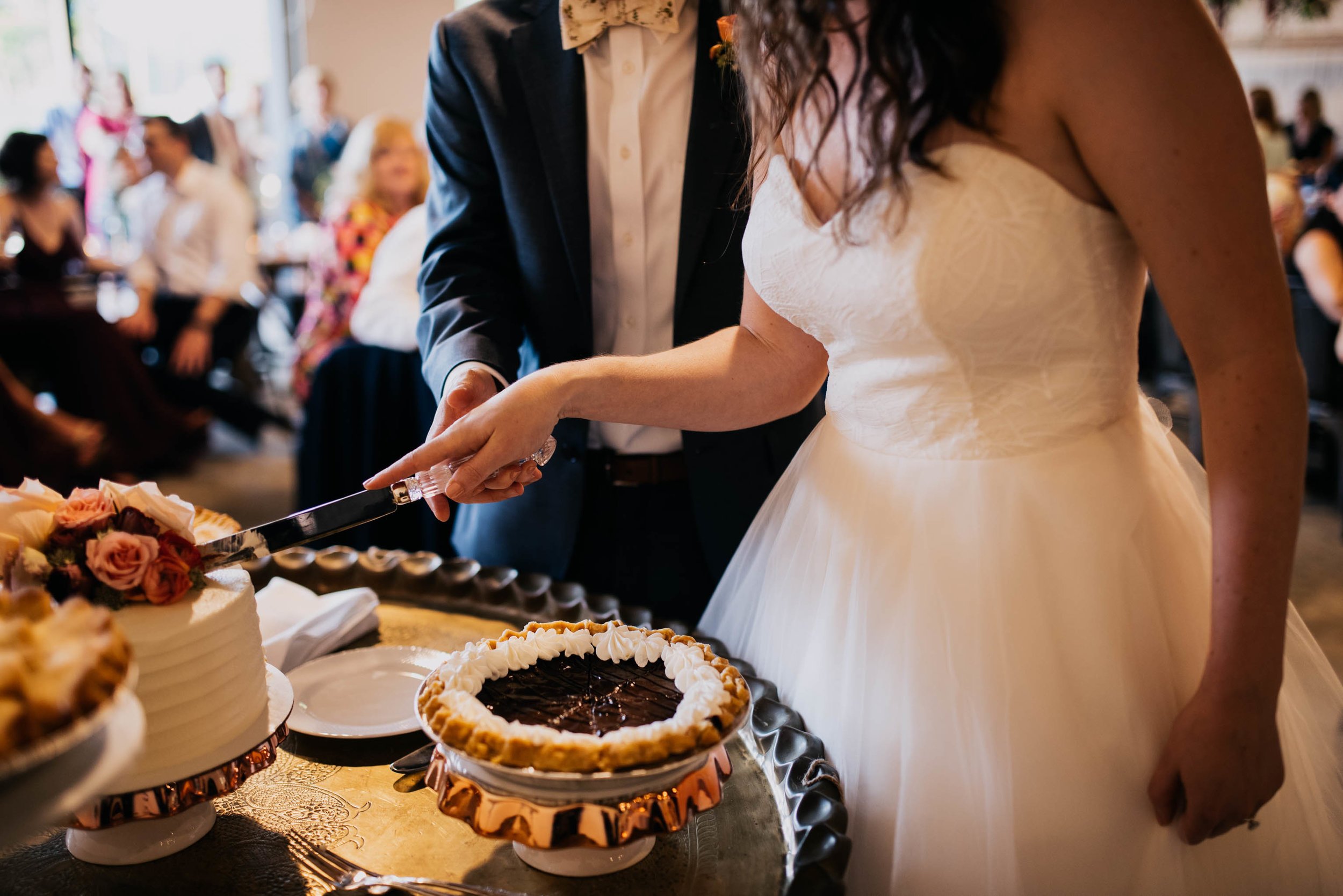 bride and groom cut the cake during their wedding reception