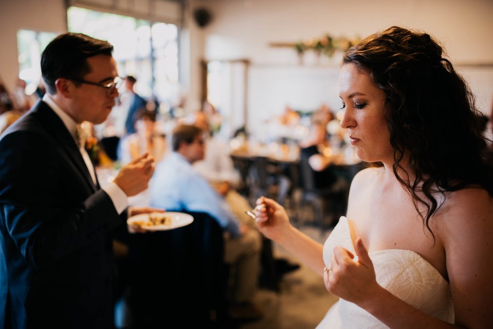 bride doing a little shimmy showing her appreciation for the wedding cake