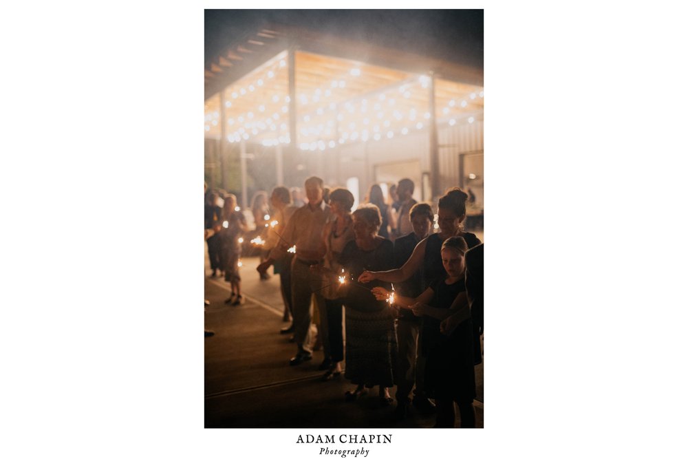 guests waving sparklers during the formal exit of the bride and groom 