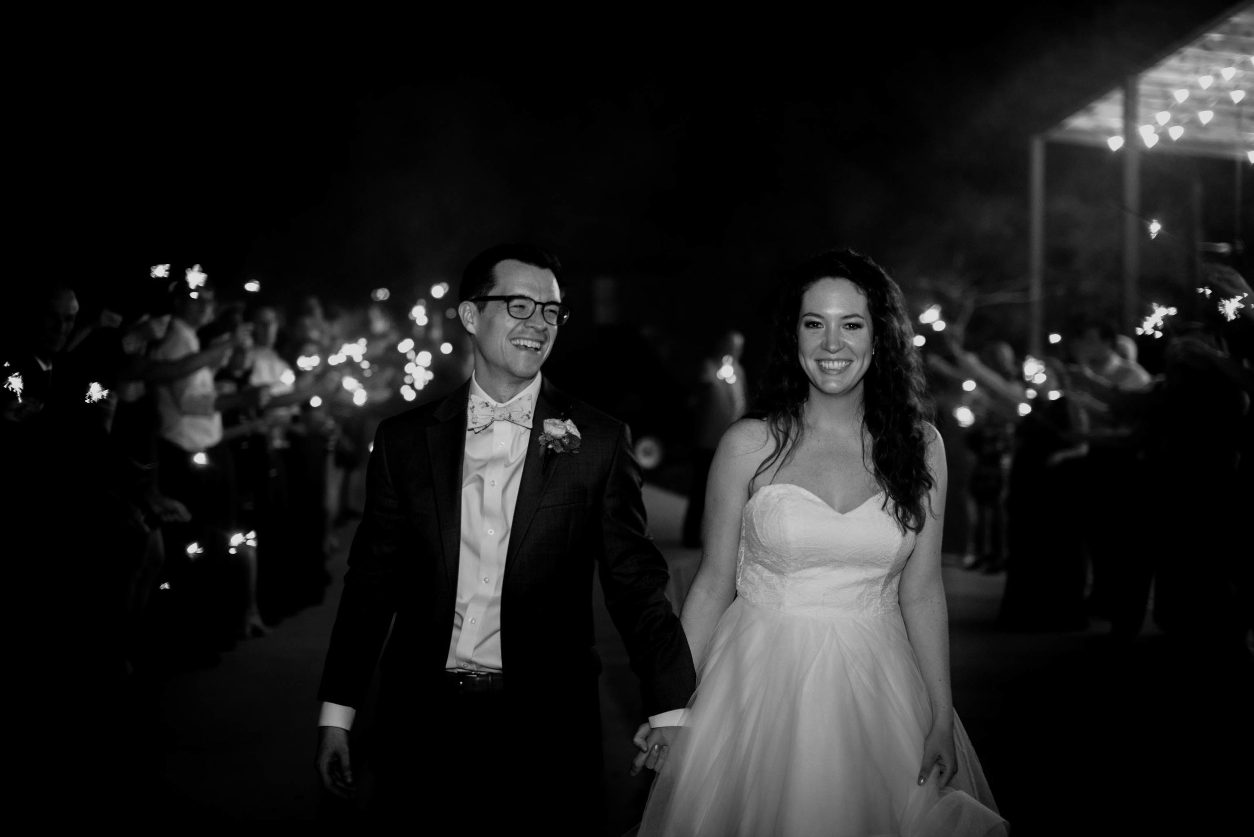 bride and groom smiling wide as they exit their wedding night