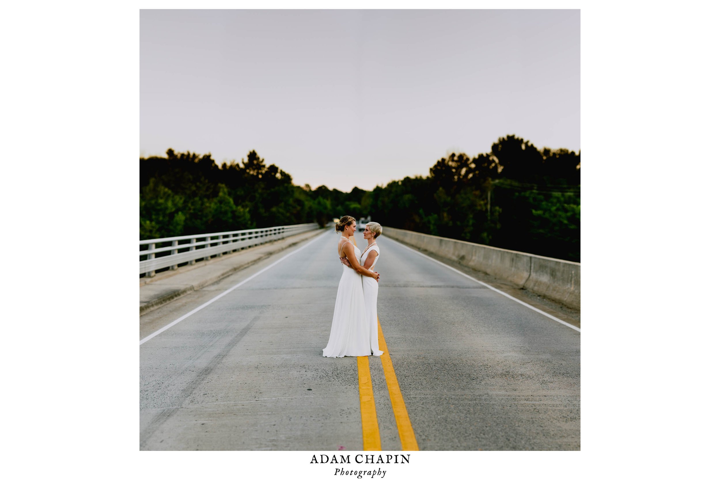 brides standing in the middle of the road on a bridge over the haw river in saxapahaw north carolina