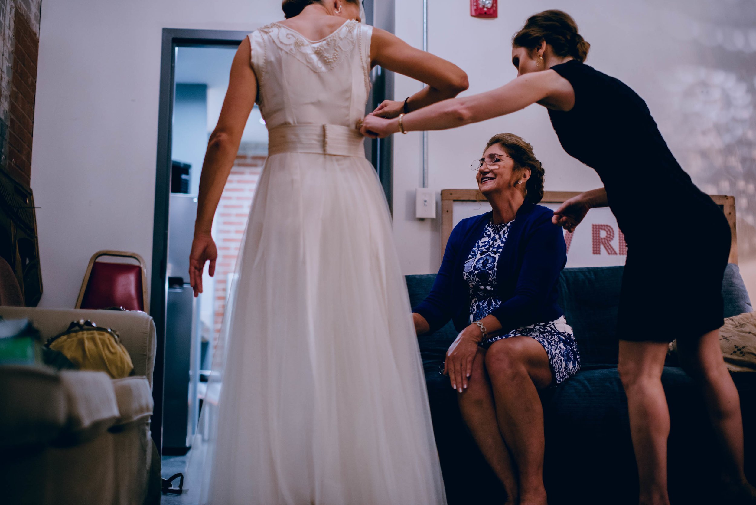 finishing touches of getting bride ready in her wedding dress