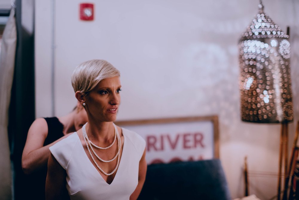 bride getting into her BHLDN dress before her wedding at the haw river ballroom