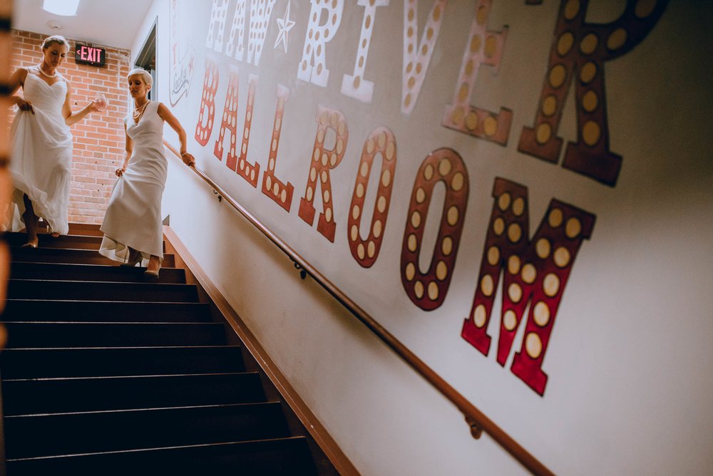 brides walking down stage stairs of the haw river ballroom