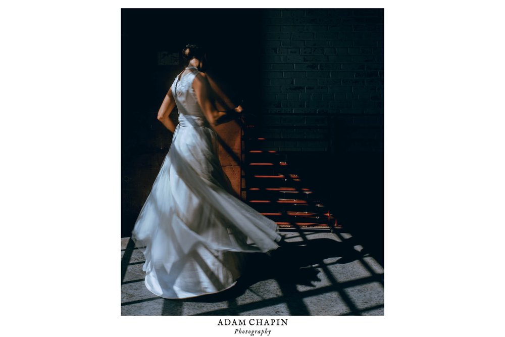 bride spinning in her dress in the window light of the balcony at the haw river ballroom