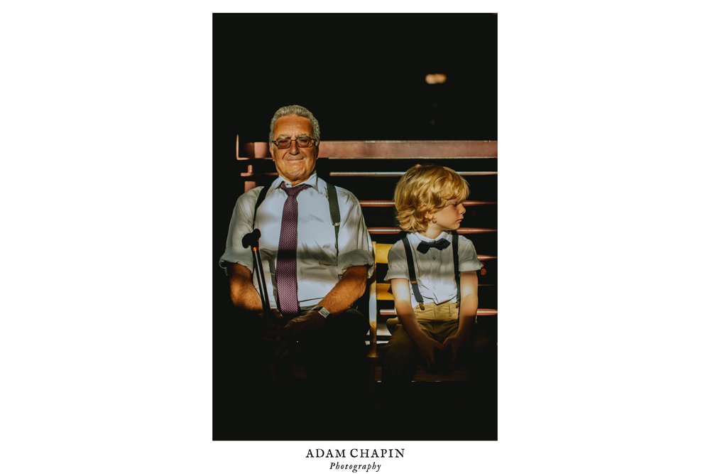 an older wedding guest and a kid sit next to each other during wedding cocktail hour