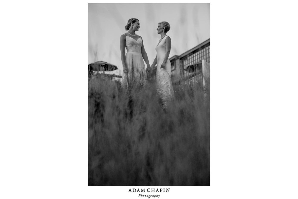 brides share a candid moment just outside the haw river ballroom