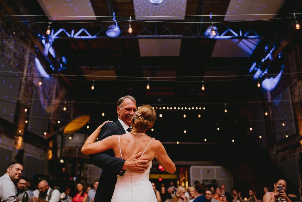 bride sharing in first dance with her father with the beautiful backdrop of the haw river ballroom