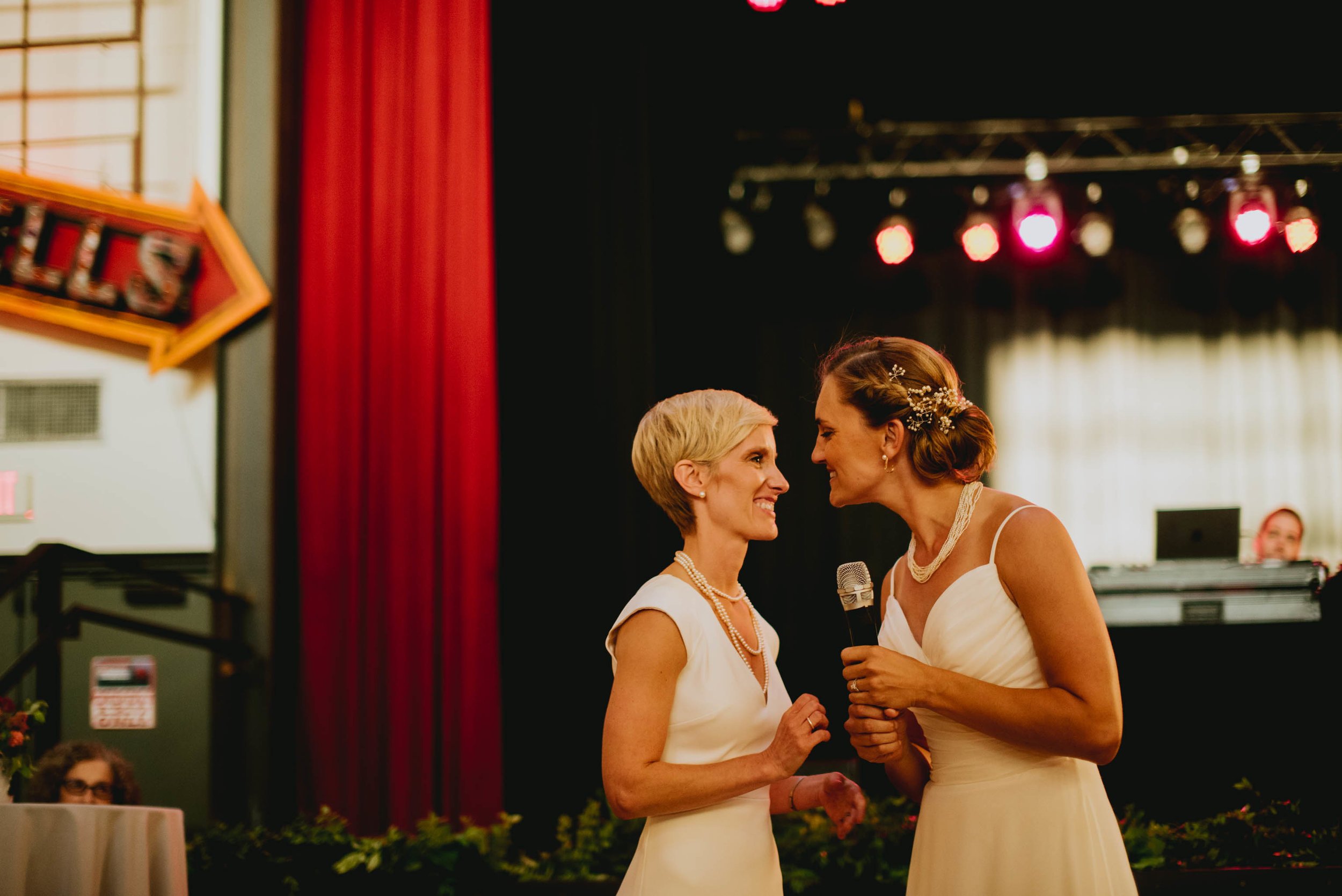 brides sharing a welcome toast to their guests at the start of their haw river ballroom wedding reception