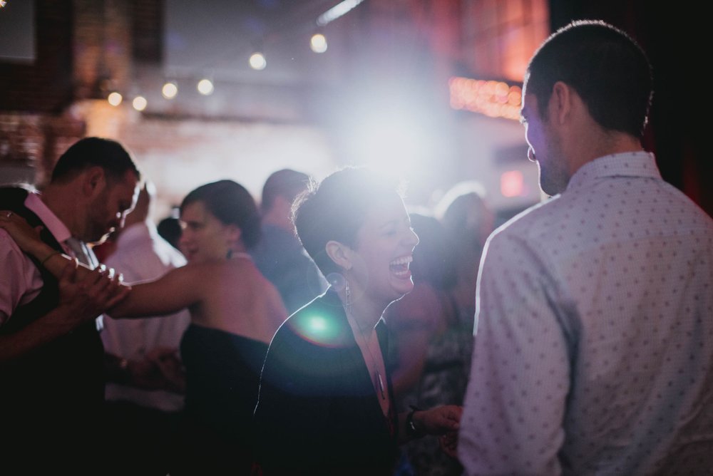 guests having a laugh while dancing during the wedding reception at the haw river ballroom