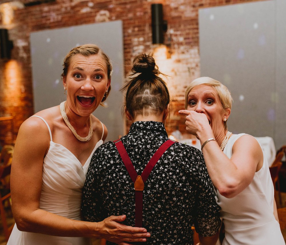 brides showing off their friends haircut that shows their first initials cut into the back of her hair
