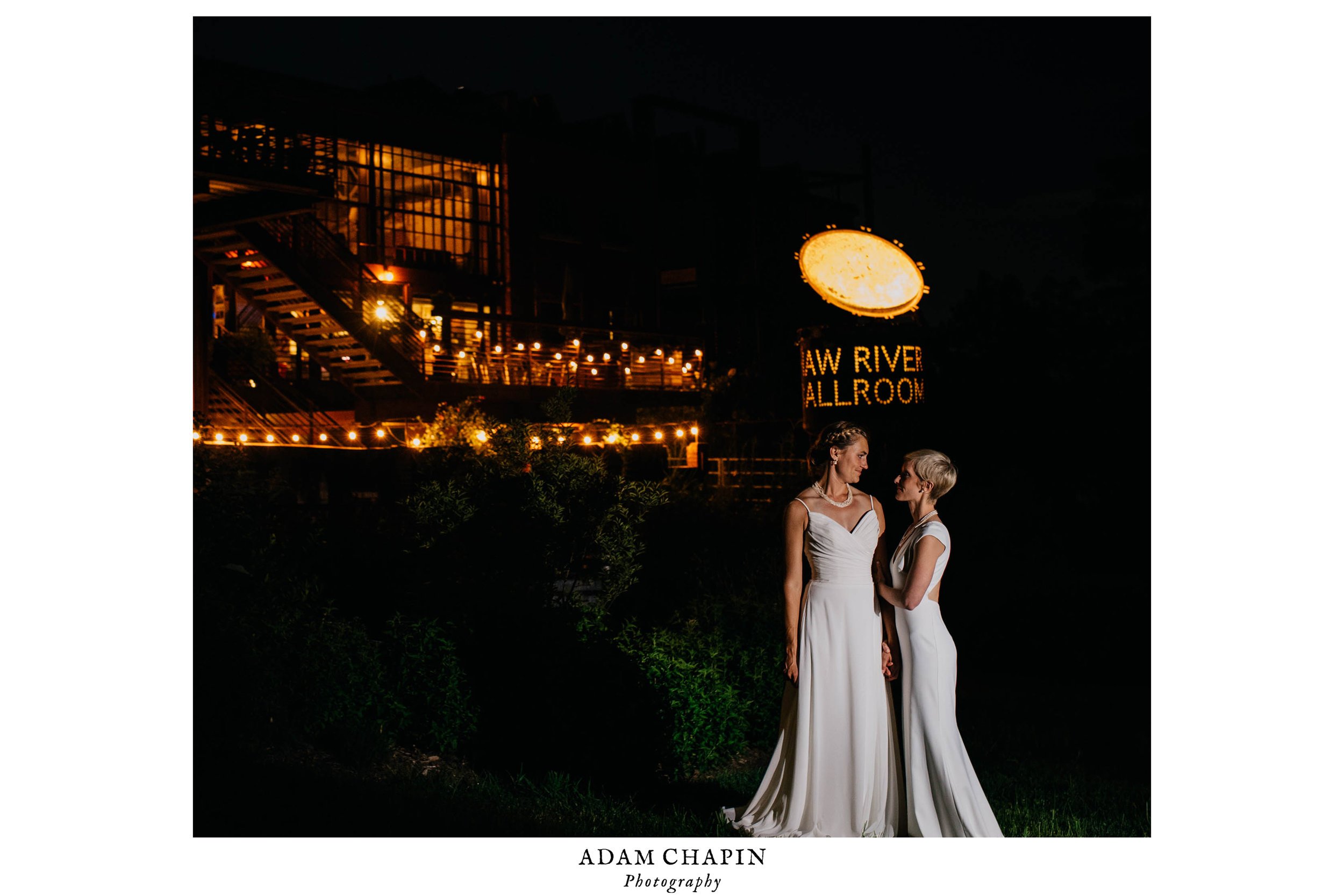 brides standing outside of the haw river ballroom the night of their wedding