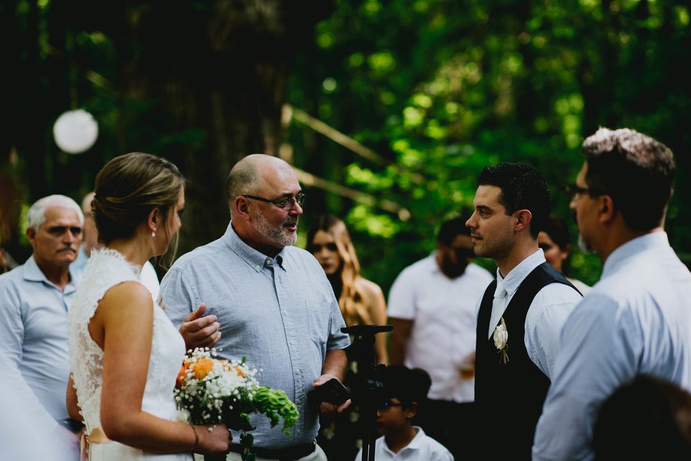 father of the bride sharing some words with guests and groom before the wedding ceremony