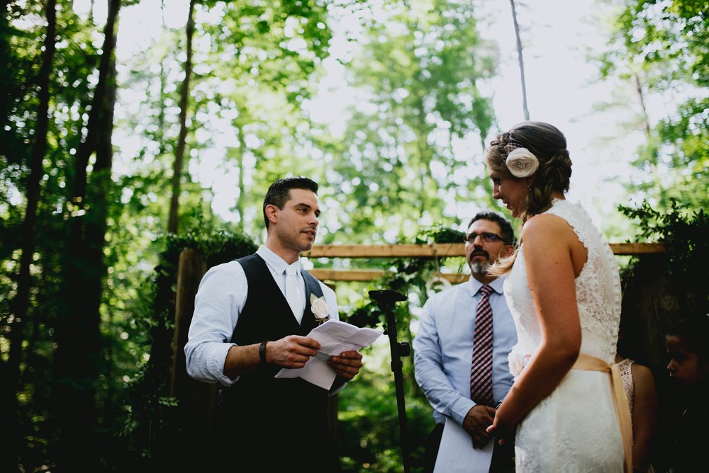 groom reading his vows to his bride during their wedding ceremony