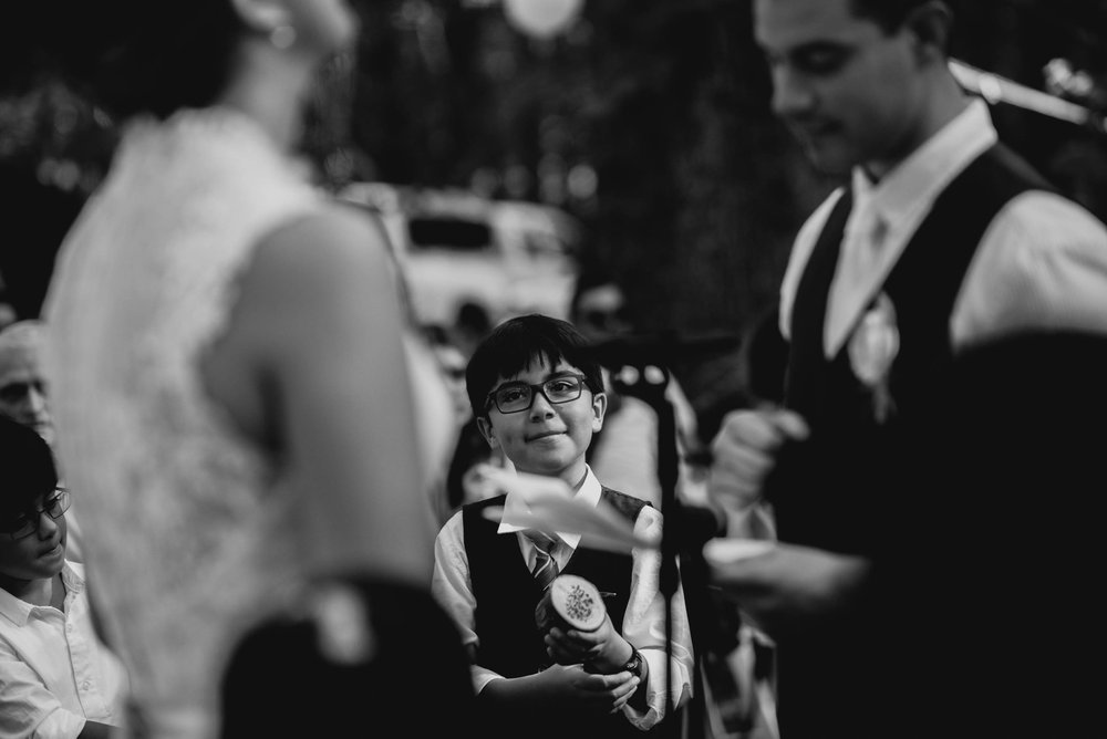 groom's nephew looking on and smiling during wedding ceremony