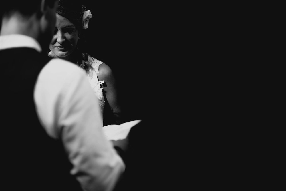 bride listening intently and smiling during grooms vow reading