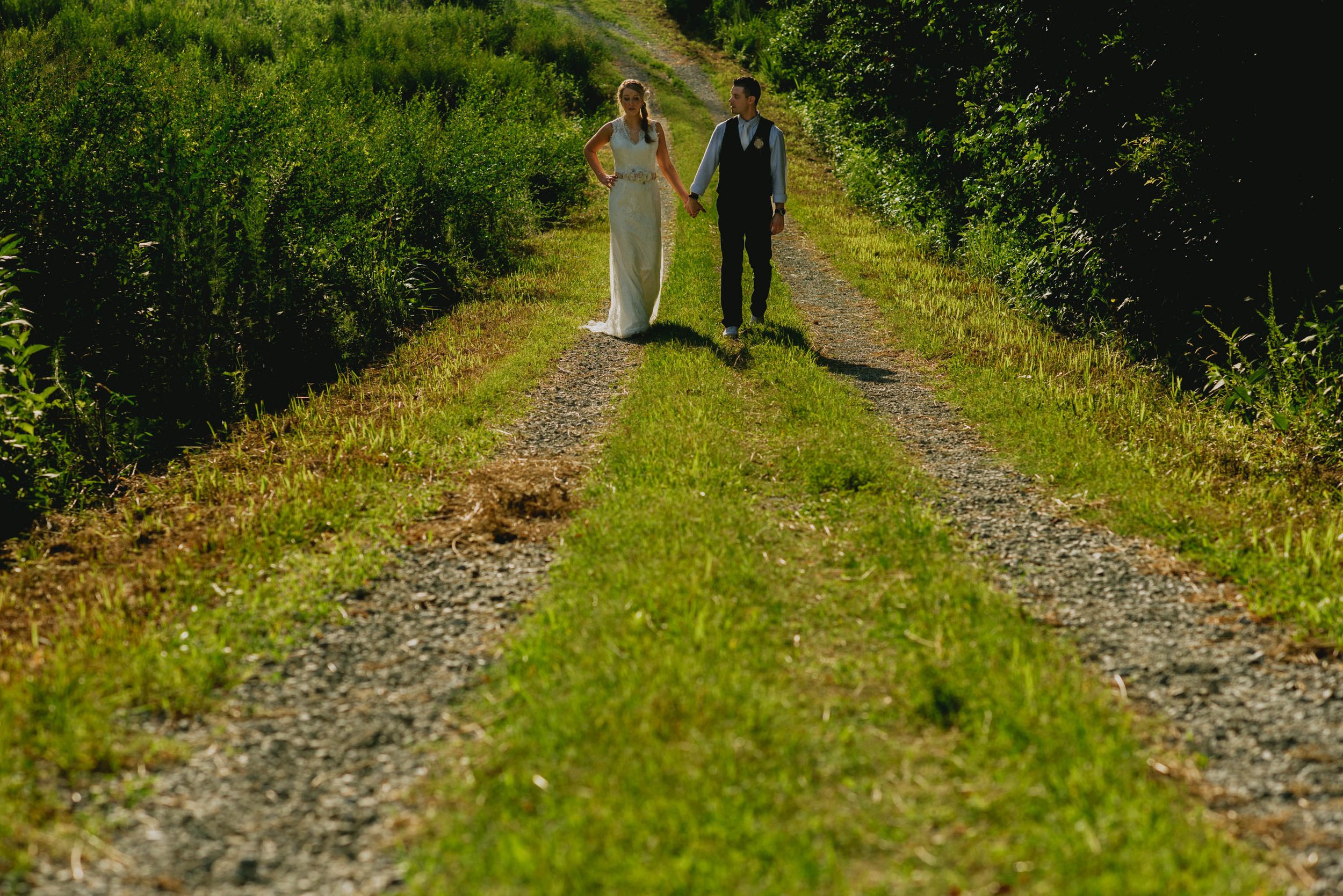 bride and groom walking down a path at their duke forest wedding