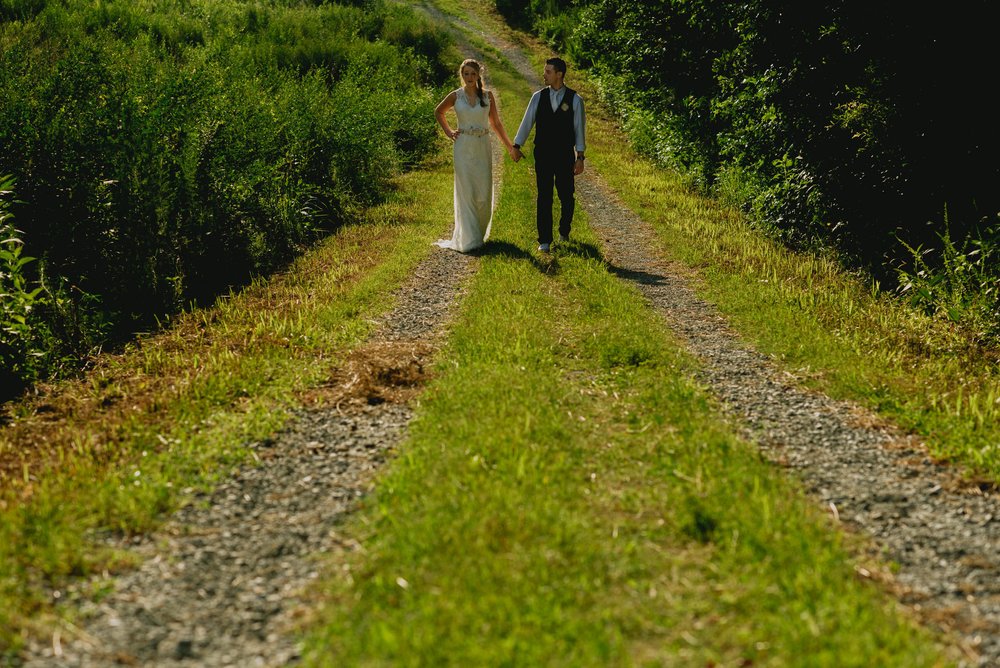 bride and groom walking down a path at their duke forest wedding