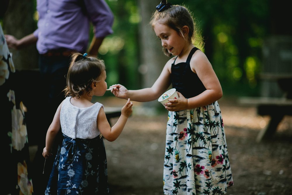 sister feeding younger sister ice cream during wedding reception