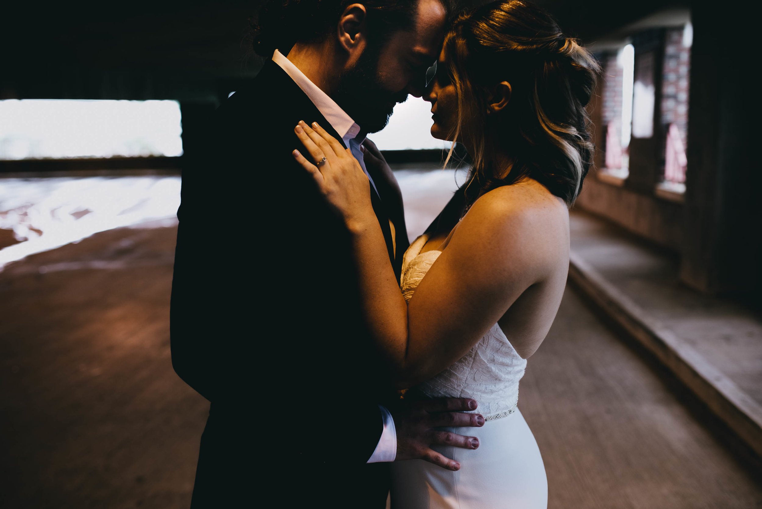 bride and groom embracing during portraits in downtown Raleigh parking garage