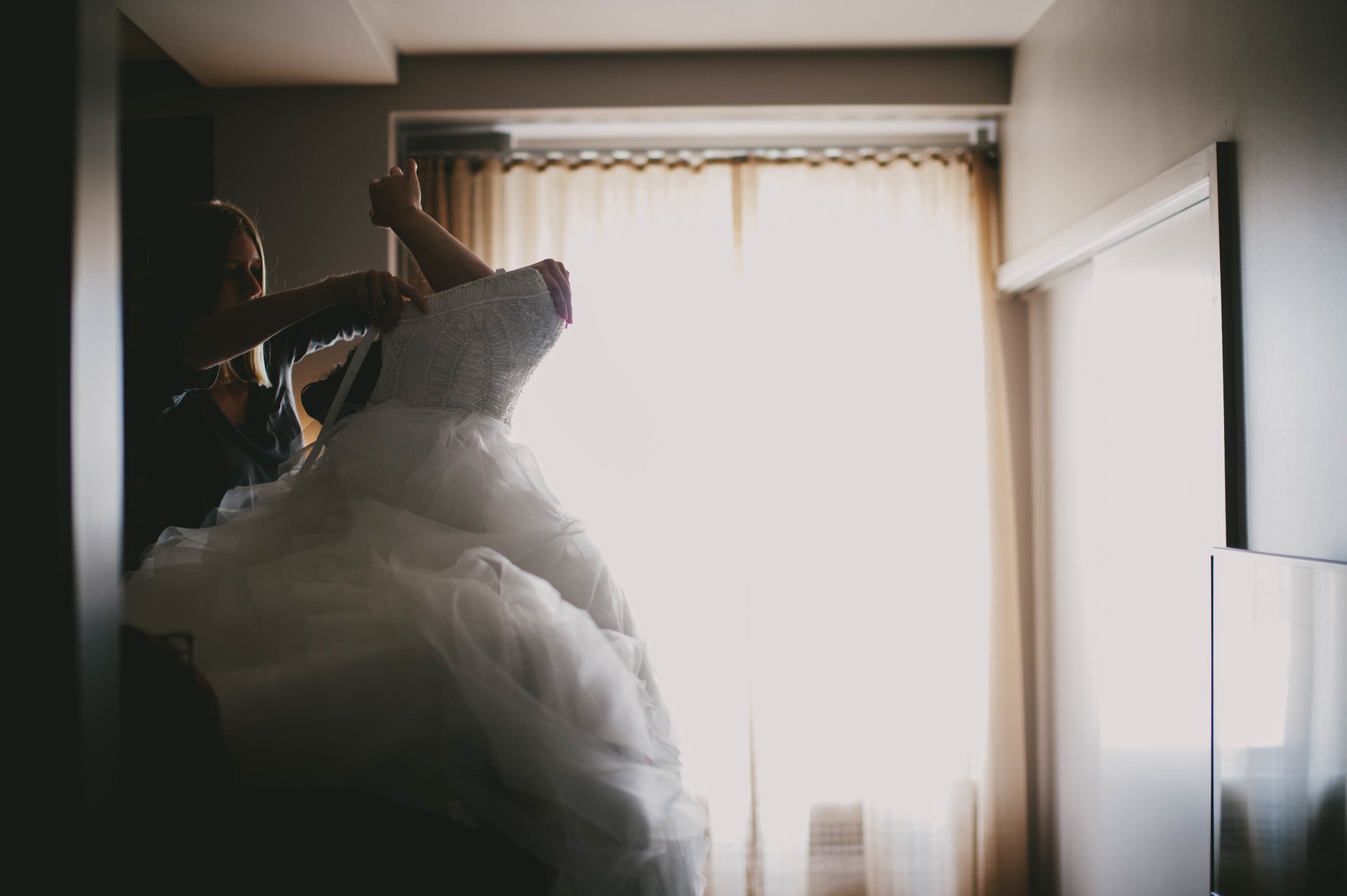 bride getting into her wedding dress at 21c hotel durham