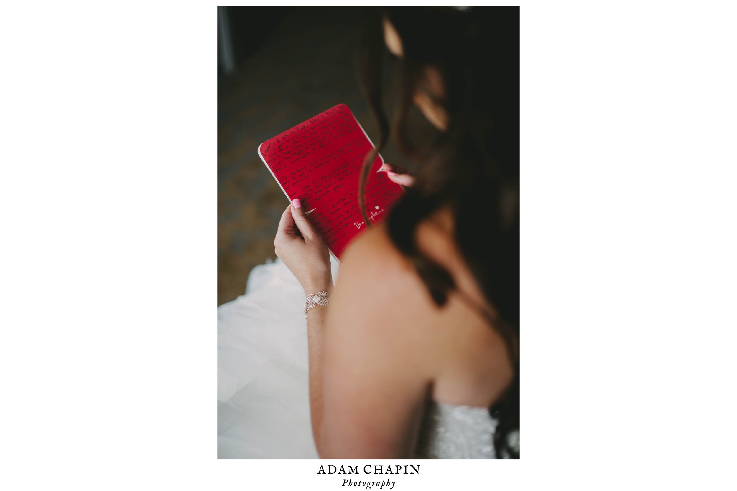 bride reading grooms card to her before their wedding ceremony