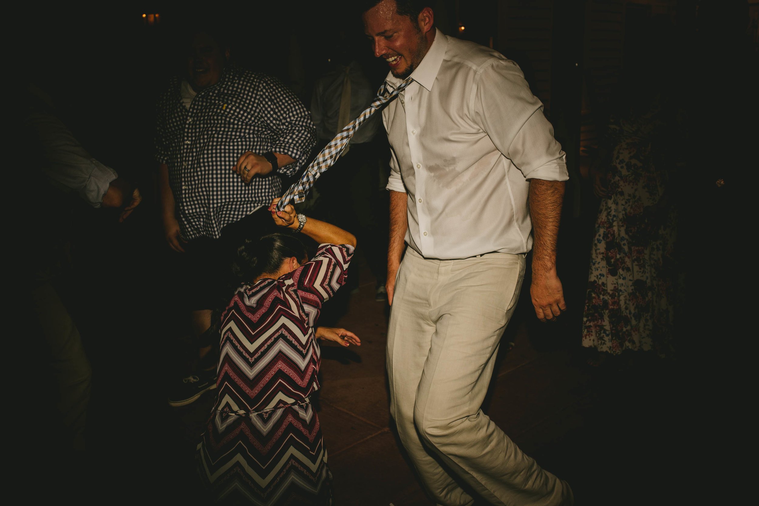 best man getting tie pulled while dancing at mims house wedding reception