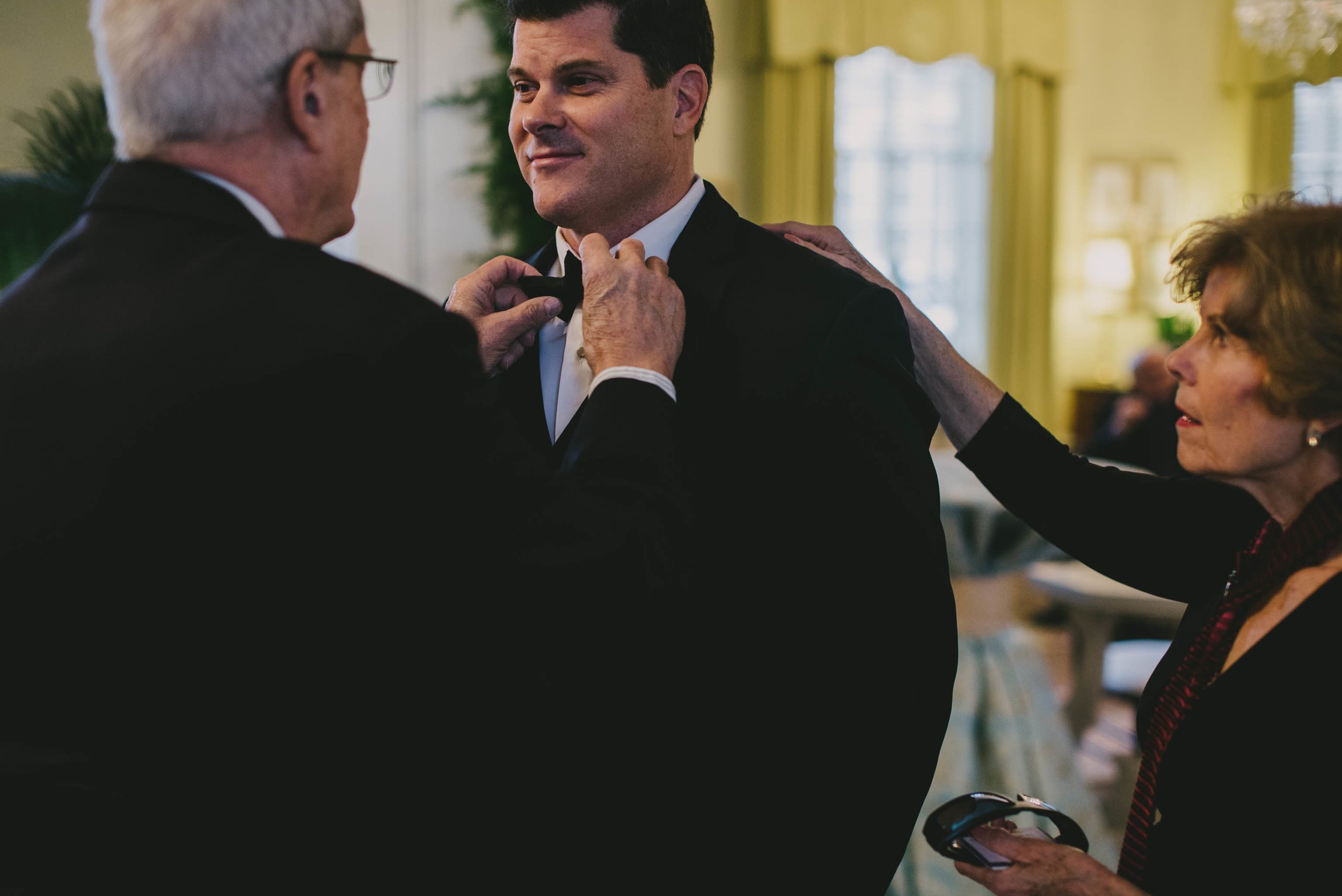 mom and dad fix the grooms bow tie