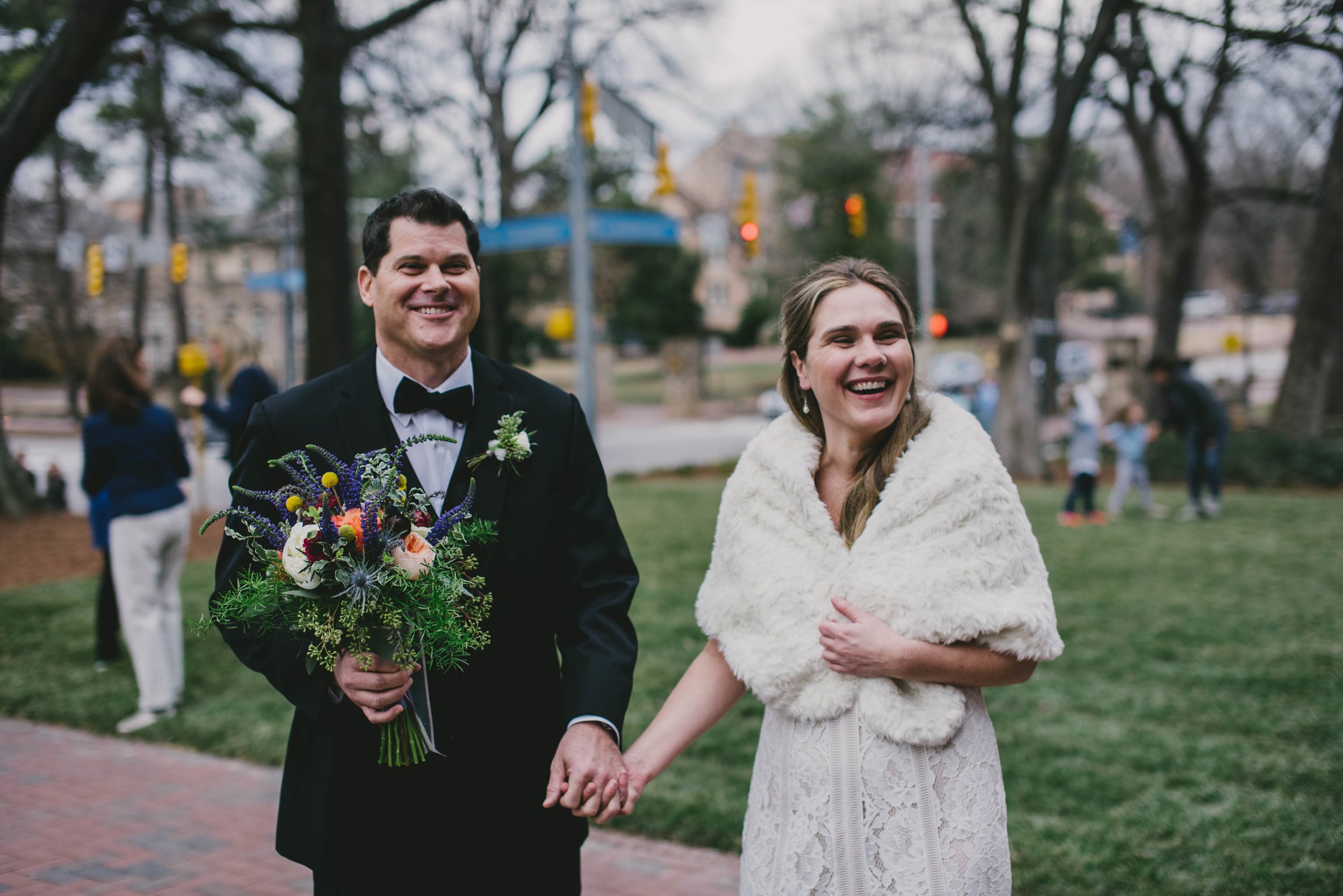 the bride laughing while wearing her beautiful white shawl for this January Carolina Inn wedding