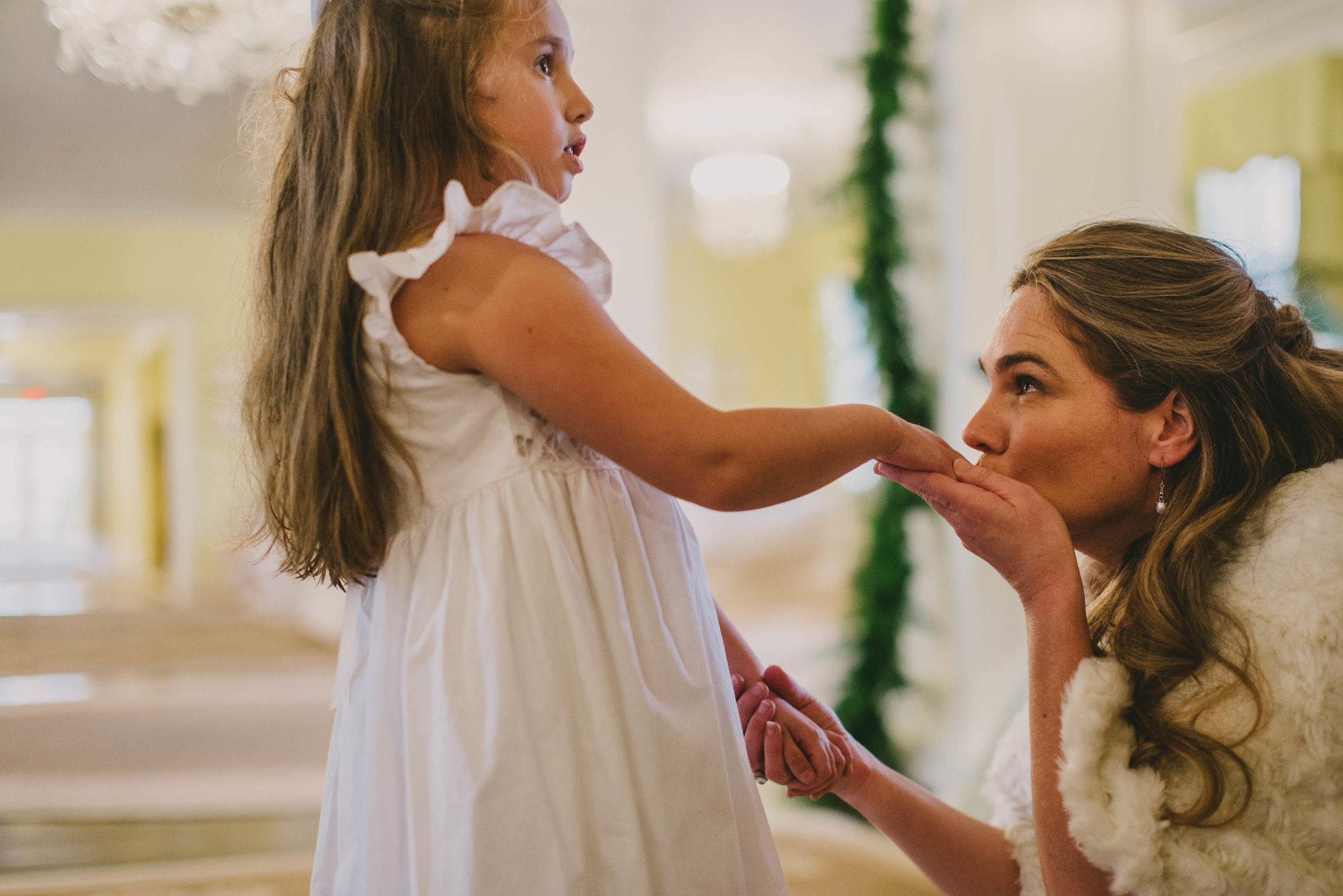 the bride kissing her daughters hand before the ceremony