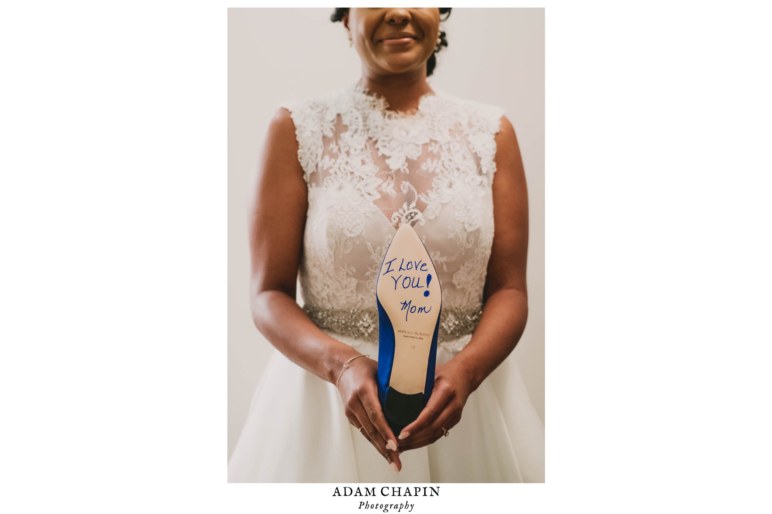 Bride holding her Manolo Blahnik heels with a note from her mom on the bottom