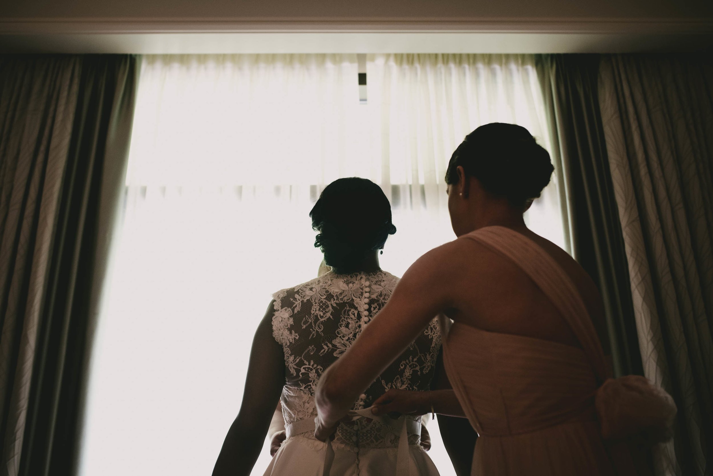 Bride getting buttoned before her wedding at the Umstead Hotel in Cary, NC