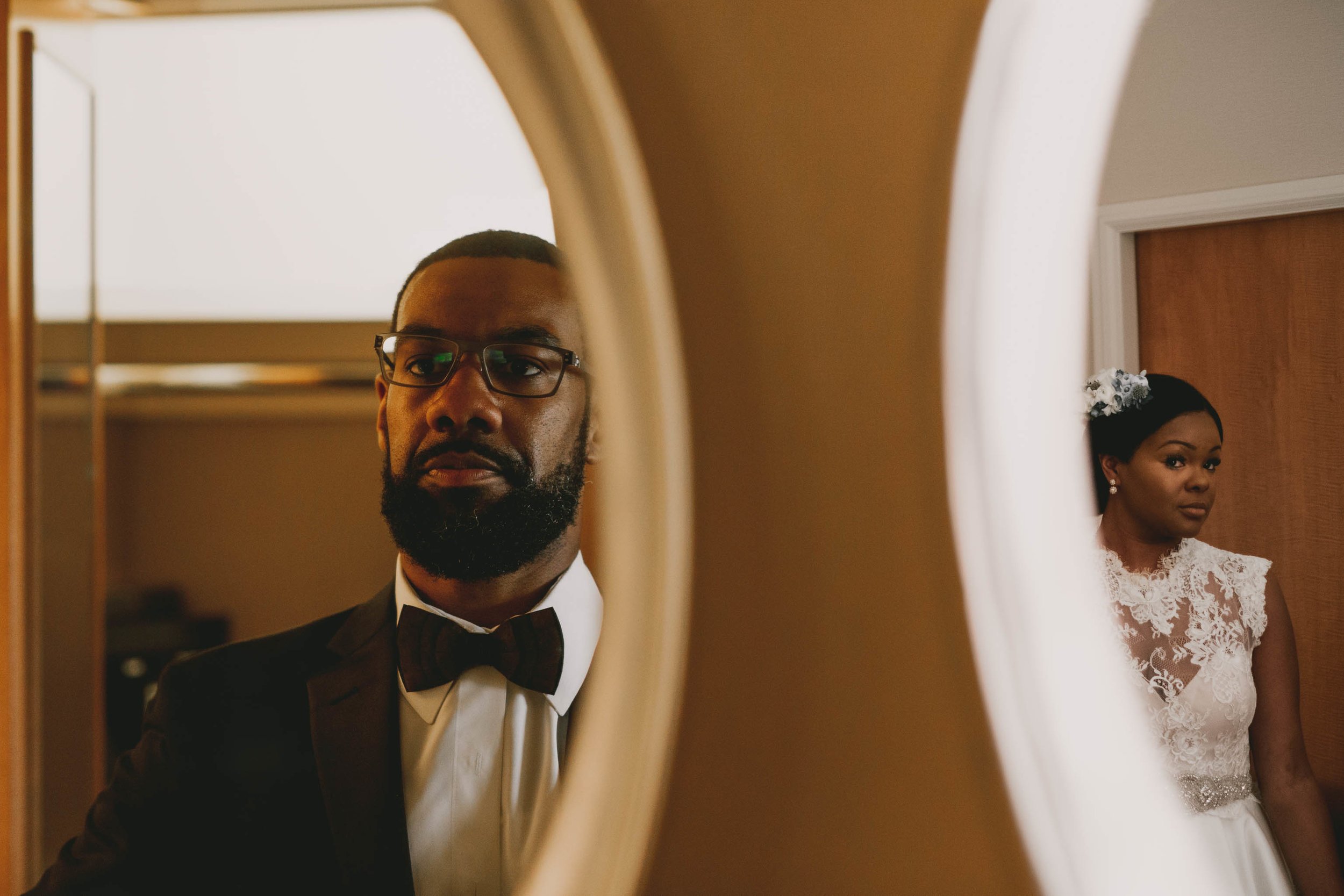 Bride and Groom sharing two mirrors in two rooms before their wedding at the Umstead Hotel