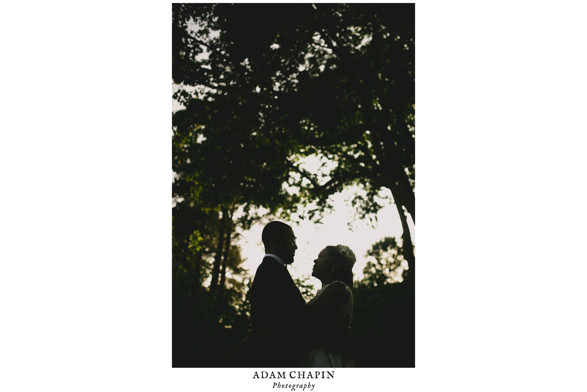 The bride and groom framed beautifully by the surrounding oak trees at the Umstead Hotel and Spa