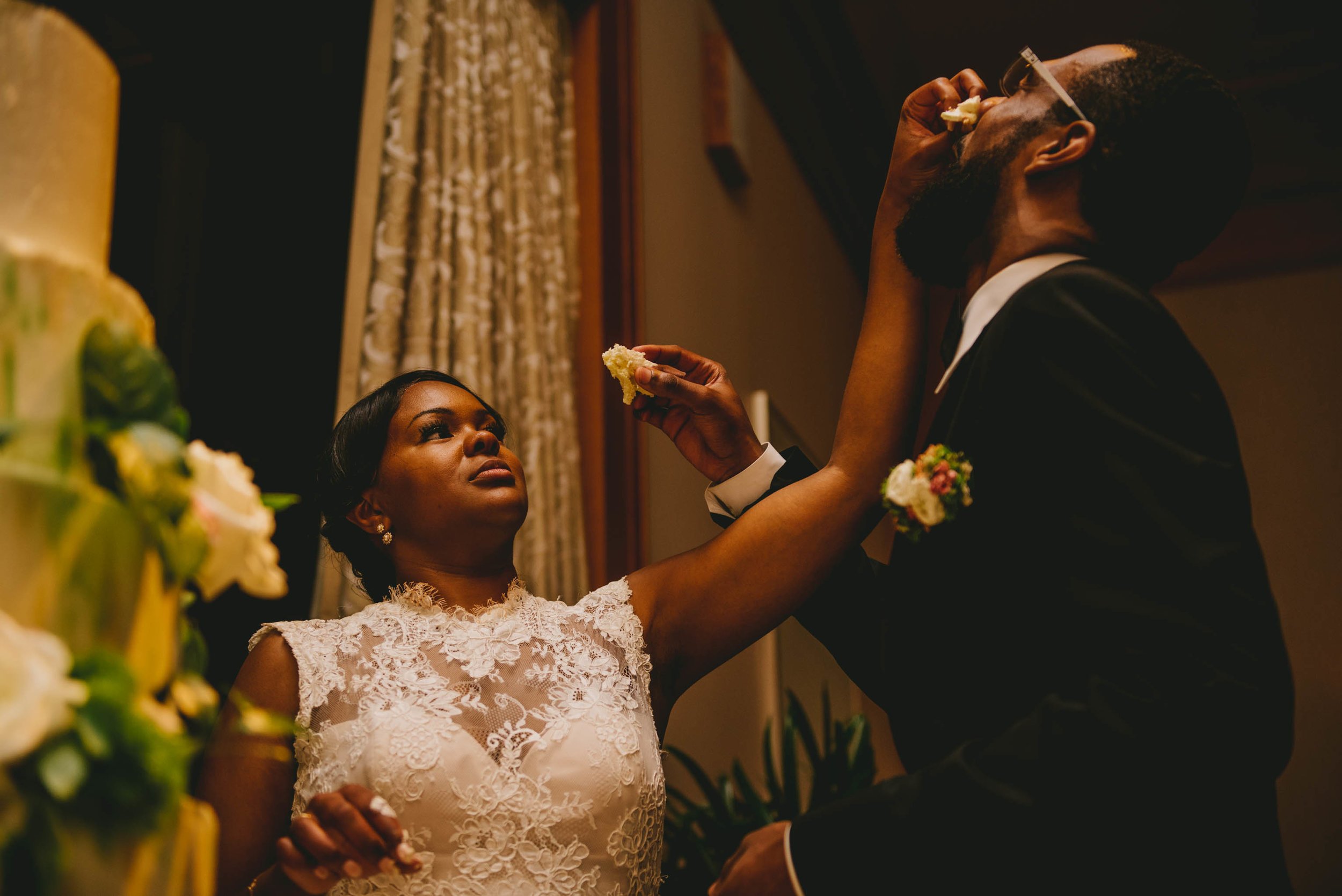 The bride smashes a piece of cake in the grooms face at the Raleigh, NC wedding