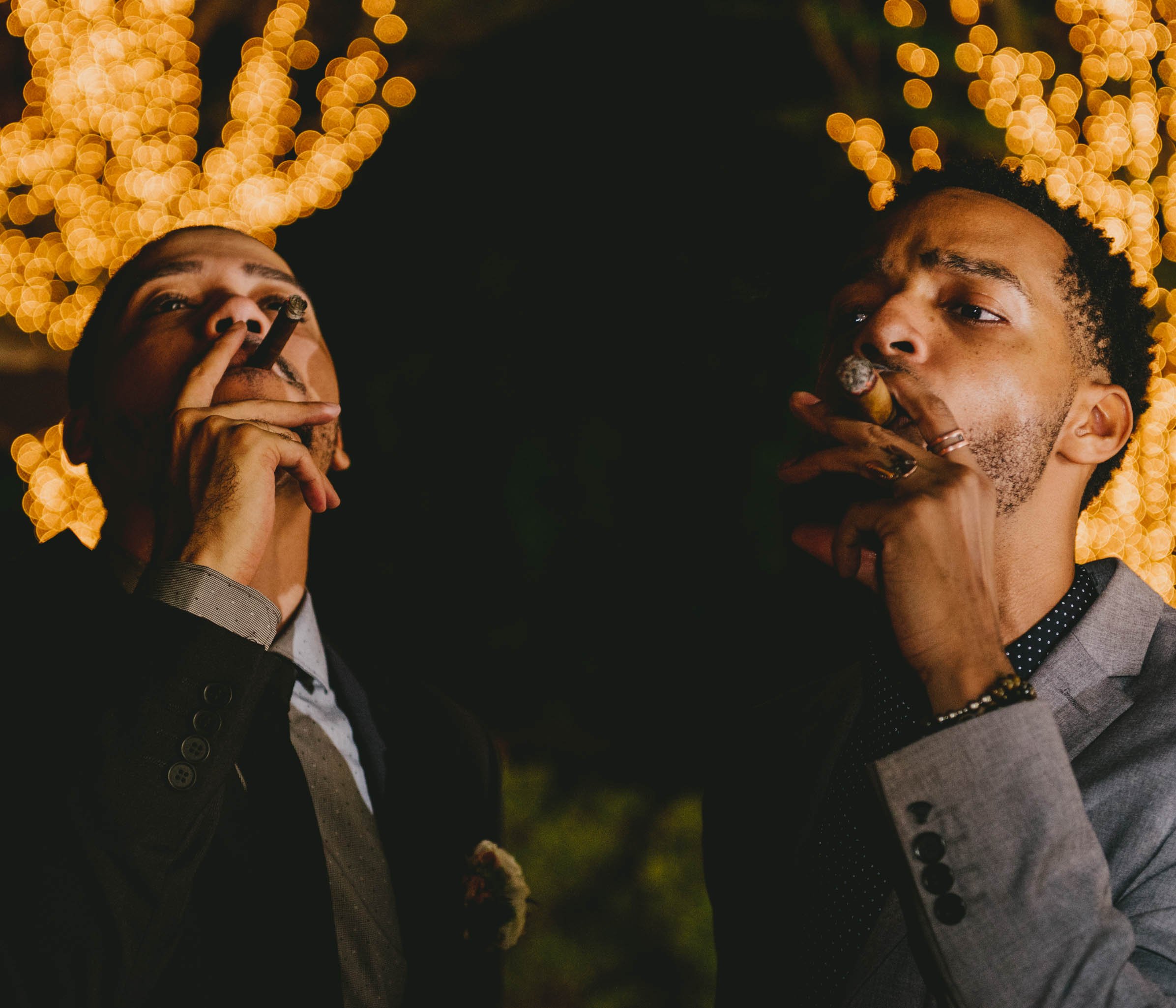 Two guests enjoy custom rolled cigars at this Umstead Hotel wedding
