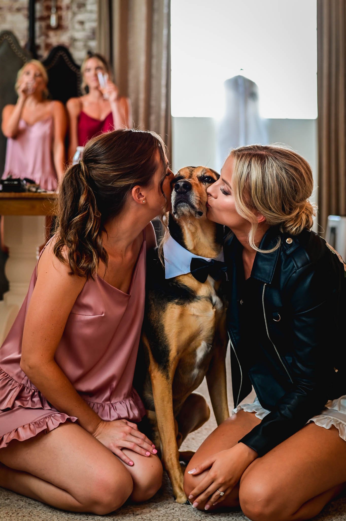 bride and bridesmaid kiss dog
