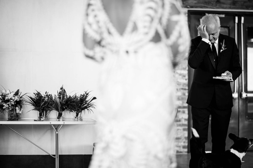 father of the bride cries as he sees his daughter for the first time in her wedding dress