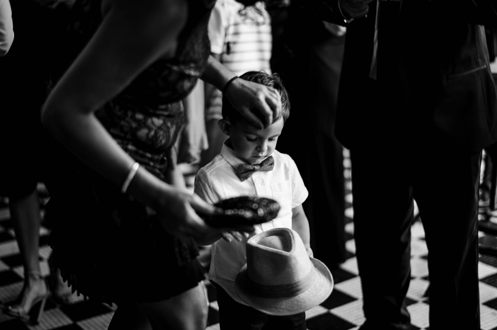 two little boys play with their fedora hats during the cocktail hour
