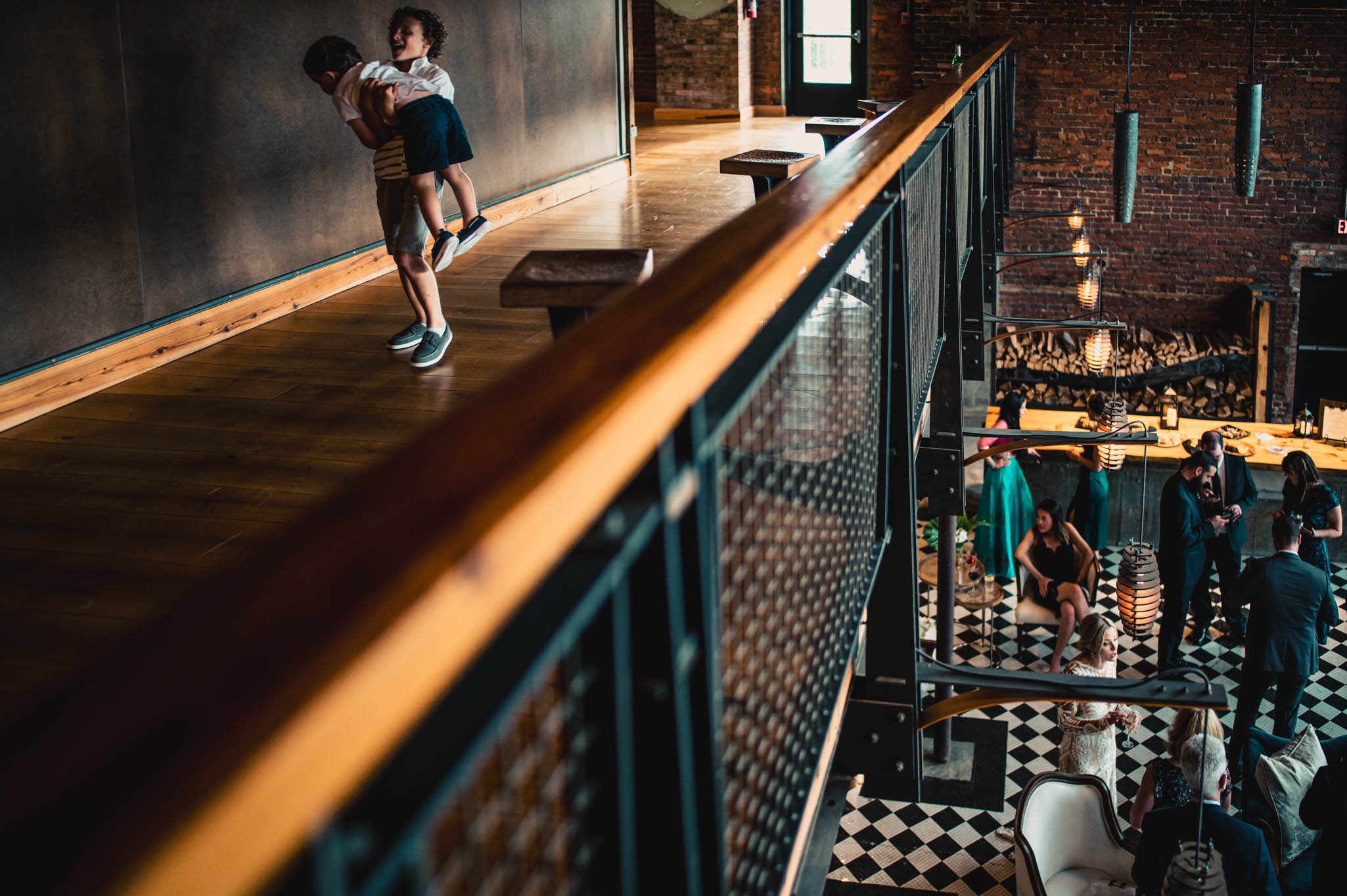 two boys wrestle on the balcony during the cocktail hour